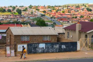 Die Gemeinde Soweto in Johannesburg, mit einkommensschwachen Wohnungen im Vordergrund und wohlhabenden Vororten im Hintergrund.