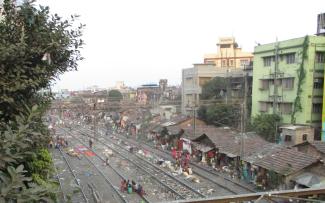 Viele Slums sind auf dem Grund der Bahn entstanden, so wie dieser in Kalkutta.