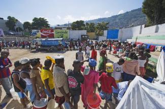 „Hilft die Hilfe?“, fragen Kritiker. Erdbebenopfer stehen in Haiti 2010 für Trinkwasser an.