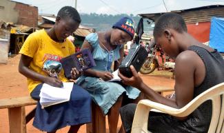 Ugandan teenagers taking part in radio schooling in the summer of 2021.