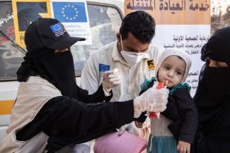 Mobile health staff caring for a malnourished infant in Yemen.