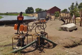Wasserträger in Terakeka, Südsudan, mit zum Verkauf angebotenen Kanistern mit Nilwasser.