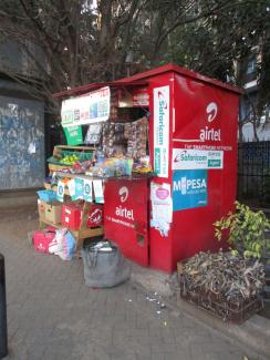 Informal shop in Nairobi with advertising for phone companies and mobile money.