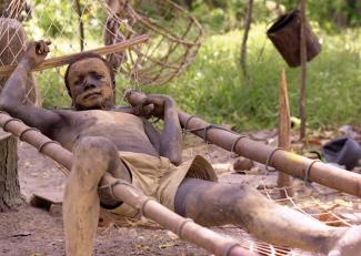 Ein Mann des Onge-Volkes ruht sich auf einer Hängematte aus.