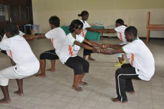 Finding balance together: YWCA-DRC leader Bibiche Kankolongo (centre) takes part in exercises herself.