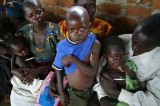 Refugee children in Uganda are waiting to be tested for malaria.