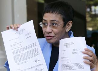 Maria Ressa showing legal documents after being released on bail.