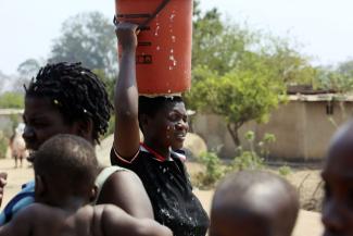 A woman in Harare, Zimbawe’s capital city, bringing home water.