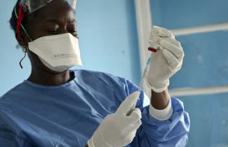 A WHO health-care worker preparing a vaccine for a front line aid-worker in Mbandaka in late May.