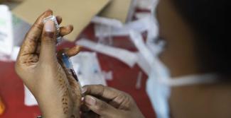 “We would have achieved more in shorter time if we had been allowed to manufacture a vaccine in Bangladesh”: Health worker preparing a shot.