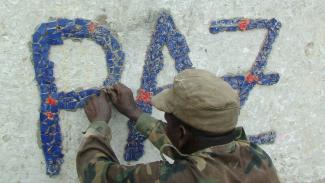 Guinean soldier decorating the “peace fountain” to commemorate the casualties of civil strife in Bissau, the capital city.