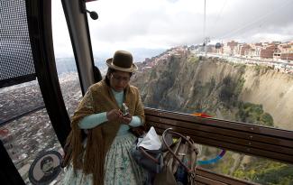 Eine indigene Frau in der Seilbahn, die die bolivianische Stadt La Paz mit der 400 Meter höher liegenden Nachbarstadt El Alto verbindet.