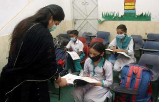 In Pakistan, girls are less likely to conclude primary school than boys: teacher with pupils in Hyderabad.