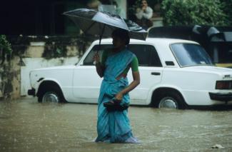 Folgen des Klimawandels beeinflussen die Arbeit von ISCOs, trotzdem wird er häufig nicht systematisch berücksichtigt. In vielen Ländern wird der Monsunregen zunehmend unberechenbar: Frau in Bombay.