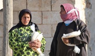 Syrerinnen mit Nothilfe-Rationen in Humaymah al-Kabira in der Provinz Aleppo.