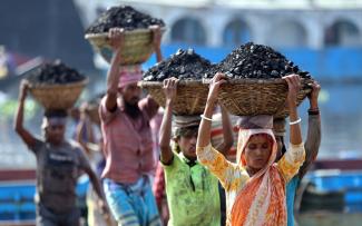 Workers unload coal from a ship in Bangladesh’s capital of Dhaka.