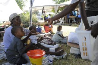 To a large degree, Haiti depends on official development assistance: staff of NPH Deutschland, a German aid agency, distributing food.