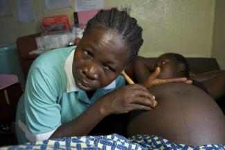 Liberian nurse examining a pregnant woman.