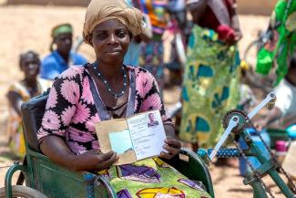 Disabled member of a women’s microfinance cooperative showing her savings book in Northern Togo.