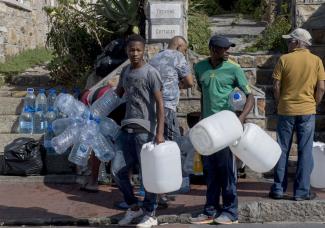 Collecting water from a public spring in a suburb of Cape Town.