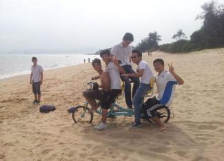 Young men enjoying a bicycle ride on the beach in the low-carbon city of Xiamen in South-West China. China is recently experiencing a bicycle and outdoor activity boom.