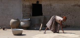 Eine Frau trocknet Getreide in Ghanas Upper West Region.