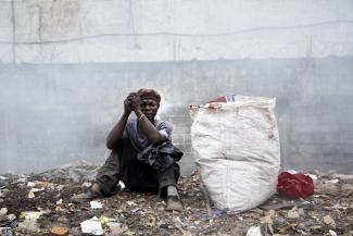 Waste collector in Sierra Leone: Donor funding is still needed to reduce poverty.