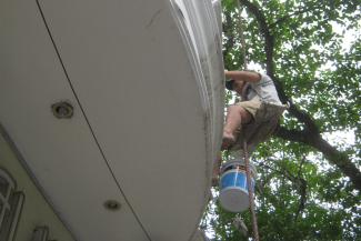 Construction workers have no social protection: ­painting a building in Hanoi.